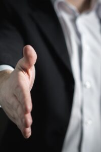 pexels-photo-327540-327540 Close-up of a businessman extending hand for a handshake, symbolizing agreement and partnership.